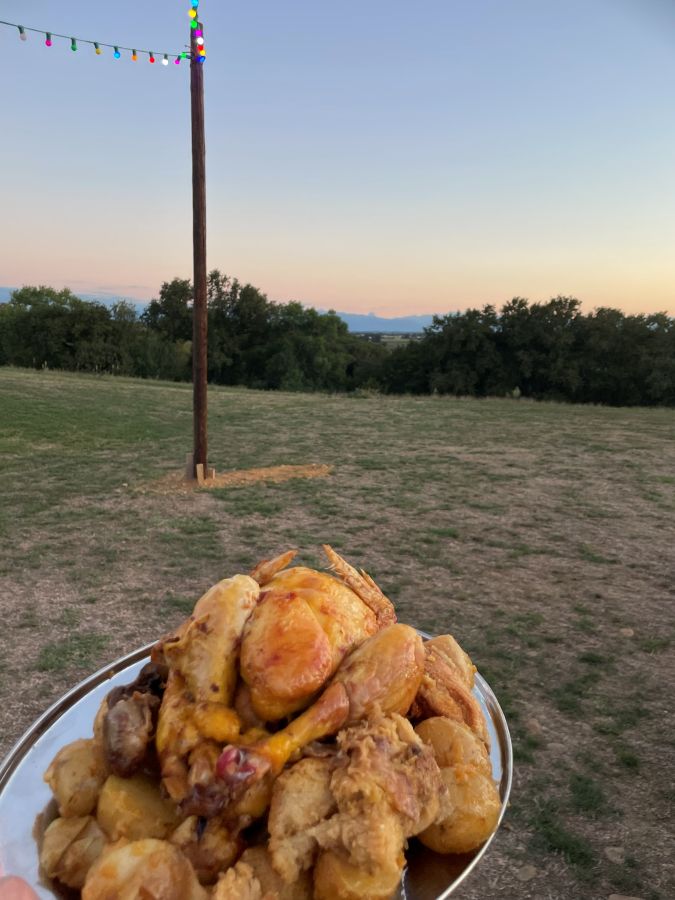 Un poulet rôti tenu au-dessus du pré
